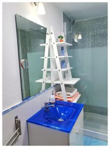 a bathroom with a blue sink in front of a mirror at Santo Domingo Suites in Granada