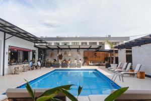 a swimming pool with a patio and a building at KC Hotel San Jose in San José