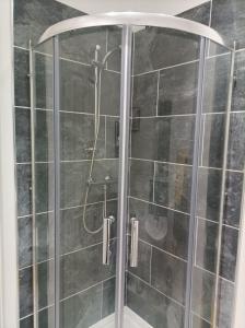 a shower with a glass door in a bathroom at Victorian Renovation Room 1 in Liverpool