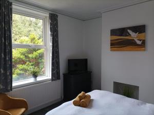 a teddy bear sitting on a bed in a bedroom at Victorian Renovation Room 1 in Liverpool