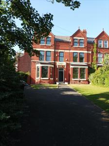 a large red brick building with a driveway at Victorian Renovation Room 1 in Liverpool