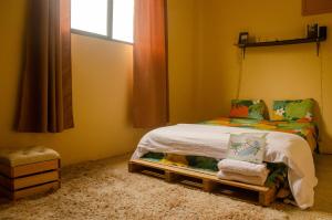 a small bedroom with a bed and a window at Pachamac House in Guayaquil