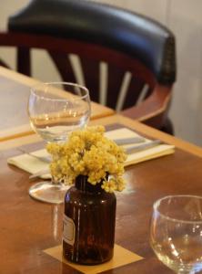 un vaso di fiori seduto su un tavolo con gli occhiali di la dame jeanne a Cucuron