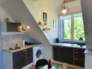 a kitchen with a sink and a washing machine at Zöld Relax Apartments in Budakeszi