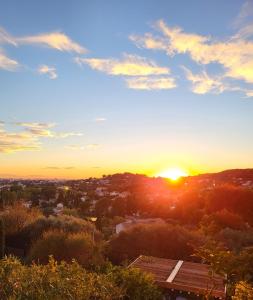 a sunset over a city with the sun setting at Chambre d hôtes AU CŒUR DES OLIVIERS in Marseille