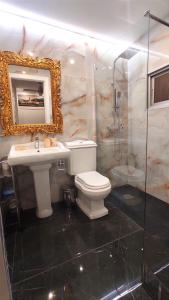 y baño con aseo, lavabo y espejo. en Gran Reserva Suites centro alojamiento entero, en Logroño