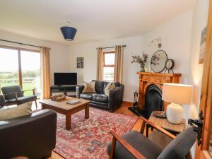 sala de estar con sofá y chimenea en Cherry Blossom Cottage en Ennis