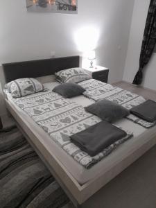 a large bed with pillows on it in a bedroom at Apartman LELA in Karlovac