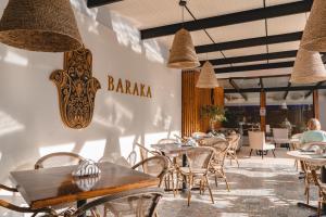 Un restaurante con mesas y sillas y un cartel en la pared. en KC Hotel San Jose, en San José