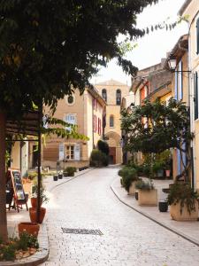 a cobblestone street in a town with houses at la dame jeanne in Cucuron