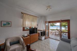 a living room with a couch and a television at Seaside Vourvourou Villa in Vourvourou
