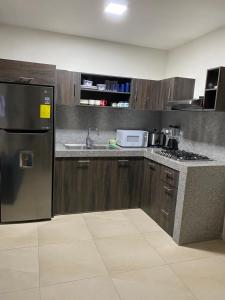 a kitchen with a stainless steel refrigerator and a sink at Alquilo hermoso departamento en Salinas, Ecuador in Salinas