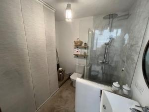 La salle de bains blanche est pourvue d'une douche et de toilettes. dans l'établissement Vistas impresionantes al mar de Garachico, à Garachico
