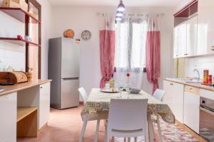 uma cozinha com uma mesa com cadeiras e um frigorífico em Casa Vita in centro em Balestrate