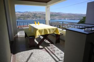 a table with a yellow table cloth on a balcony at Apartments Pavicic Marija in Pag