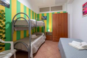 um quarto com 2 beliches e riscas verdes e amarelas em Casa Vita in centro em Balestrate