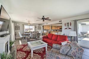 Una sala de estar con un sofá rojo y una mesa. en 2 Mi to Lake Havasu State Park Home with Pool!, en Lake Havasu City