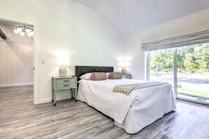 a white bedroom with a bed and a window at Modern Escape with Fire Pit, Near Lake Waramaug in Kent