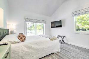 ein weißes Schlafzimmer mit einem Bett und einem TV in der Unterkunft Modern Escape with Fire Pit, Near Lake Waramaug in Kent