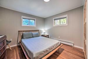 ein Schlafzimmer mit einem Bett und zwei Fenstern in der Unterkunft Secluded Suttons Bay Retreat with Fire Pit! in Suttons Bay