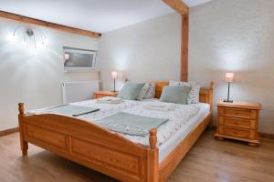 sypialnia z drewnianym łóżkiem i 2 szafkami nocnymi w obiekcie Pokoje u świętego Krzysztofa we Wrocławiu