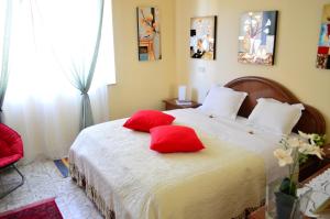a bedroom with a bed with red pillows on it at Apartment with Beautiful Sun in Montepulciano