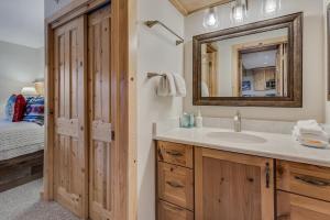 a bathroom with a sink and a mirror and a bed at Laurelwood Condominiums 106 in Snowmass Village