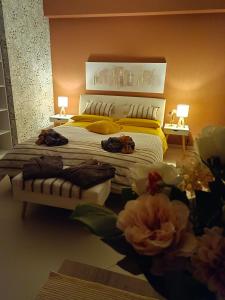 ein Schlafzimmer mit einem großen Bett mit gelben Kissen und Blumen in der Unterkunft Villa Sant'Andrea in Trecastagni