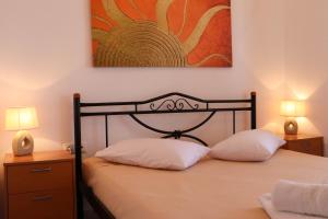 a bedroom with a bed with two pillows and a painting at Louvis House in Akti Salonikiou