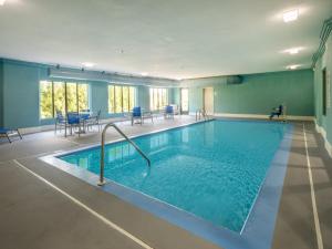 a large swimming pool in a room with tables and chairs at Holiday Inn Express Gas City, an IHG Hotel in Gas City