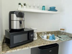 a kitchen counter with a coffee maker and a microwave at Elegante Blue Marine Apartamento Juan Dolio in Juan Dolio