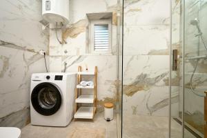 a washing machine in a bathroom with a shower at Zora Residence in Kaštela +20 photos