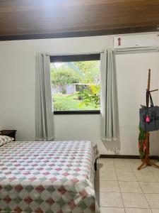 1 dormitorio con cama y ventana en - Apto Pimenta Rosa - Village Praia de Imbassaí en Imbassai