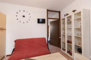 ヴェローナにあるCasa Kataleaのリビングルーム(赤いソファ、壁掛け時計付)