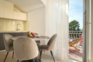 a kitchen and dining room with a table and chairs at Zora Residence in Kaštela