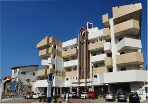 um grande edifício com carros estacionados em frente em ARCUS Hotel By Atlântica em Aracaju