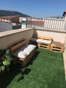 a patio with two beds on a balcony with grass at Casa Nueva en Barco frente a Sierra de Gredos in El Barco de Ávila