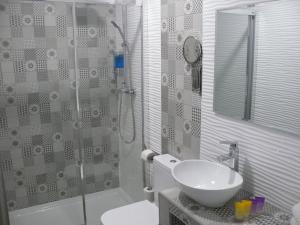 La salle de bains est pourvue d'un lavabo et d'une douche en verre. dans l'établissement HOSTAL LETTO DAL MARE, à Valence