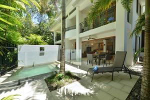 eine Villa mit einem Pool und einem Haus in der Unterkunft Villa Frangipani in Port Douglas