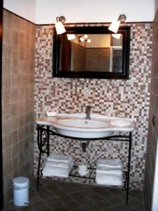 ein Bad mit einem Waschbecken und einem Spiegel in der Unterkunft Hotel Dei Templi in Paestum