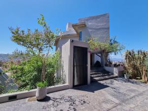 a white house with a door and a tree at Barrancas de Nieva B03 in San Salvador de Jujuy