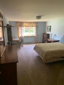 Schlafzimmer mit einem Bett, einem Schreibtisch und einem Fenster in der Unterkunft Kenway Ranch in Southwest Harbor