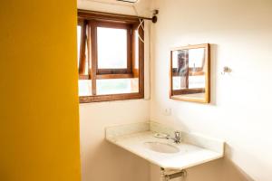 a bathroom with a sink and a mirror at Vila Juquehy Lofts & Suítes in Juquei