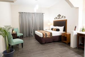 Sueños Resort في El Porvenir: غرفة نوم بسرير وطاولة وكرسي