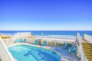 a swimming pool with chairs and the beach at Your Turn in Surf City