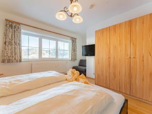 sypialnia z dużym białym łóżkiem i dużą drewnianą szafką w obiekcie Vicky Apartment Large w mieście Niederau