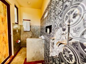 a bathroom with a black and white patterned wall at A&V Hotel Boutique in Acapulco