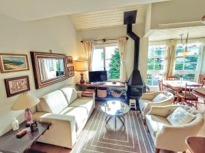 uma sala de estar com um sofá e uma lareira em Agradável Apt 2Quartos para família próx ao Lago Negro - 4 min do centro- com churrasqueira em Gramado