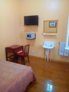 a room with a bed and a table and a sink at Hotel Isabel in Mexico City