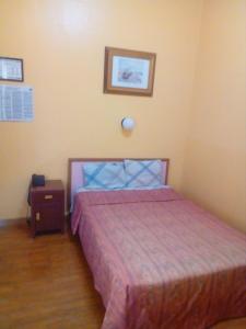 een kleine slaapkamer met een bed en een nachtkastje bij Hotel Isabel in Mexico-Stad